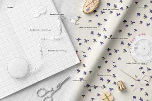 Cotton fabric with a floral pattern beside an open sketchbook, sewing tools and buttons arranged on a flat surface.