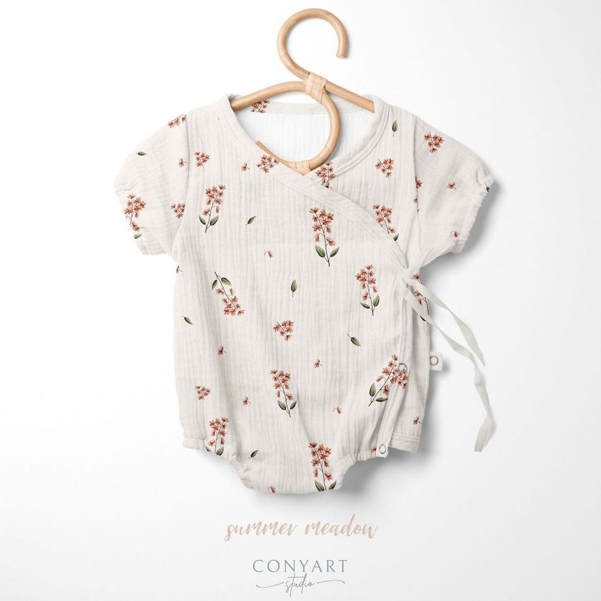 Muslin onesie mockup featuring a short-sleeve baby romper with a floral pattern on a wooden hanger against a white background.