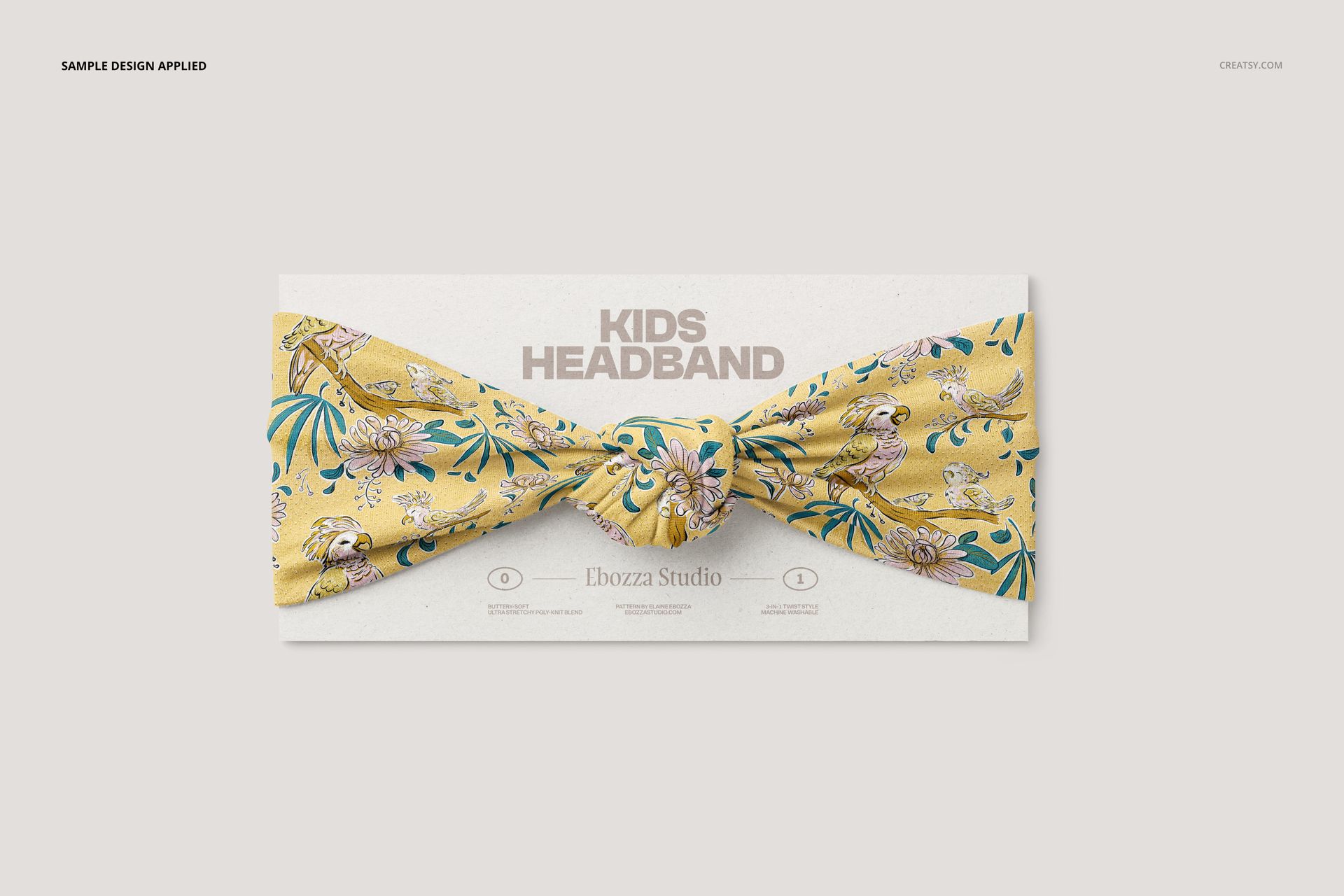 Front view of a kids twist knot headband mockup with a yellow fabric featuring playful animal and leaf patterns.