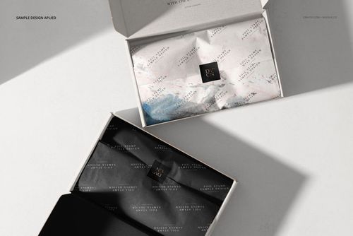 Open mailing boxes mockup showing interior details, including folded tissue paper in contrasting black and white designs.