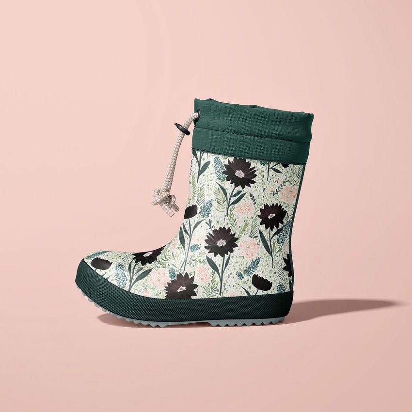 Kids rain boots mockup featuring a side view of a single boot with a green sole and floral pattern on a light pink background.