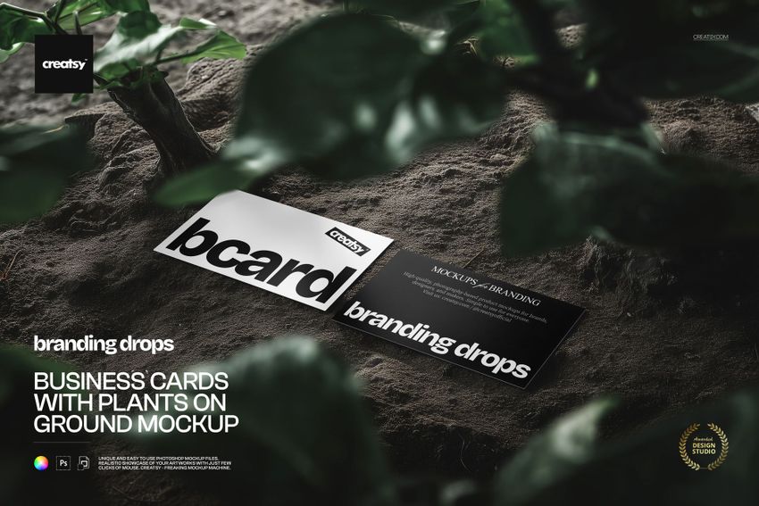 Two rectangular business cards placed on earthy ground with leafy plants, presented as a PSD mockup.