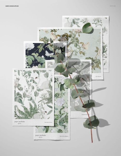 PSD mockup showing multiple cotton fabric swatches in soft green and neutral tones, decorated with a real eucalyptus branch.