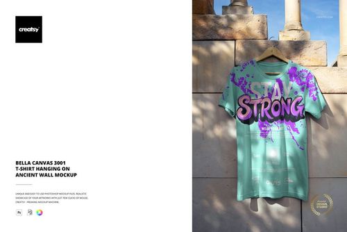 PSD mockup showing a graphic adult t-shirt draped against a textured ancient wall, illuminated by natural sunlight.