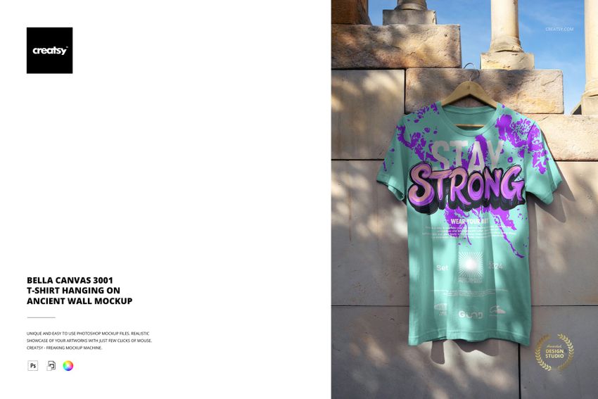 PSD mockup showing a graphic adult t-shirt draped against a textured ancient wall, illuminated by natural sunlight.