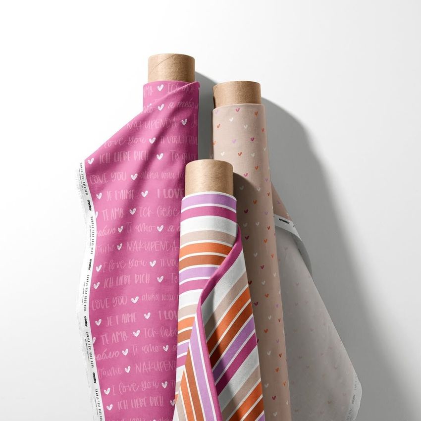 Fabric rolls mockup featuring three upright rolls with pink, beige, and striped patterns, set against a white background.