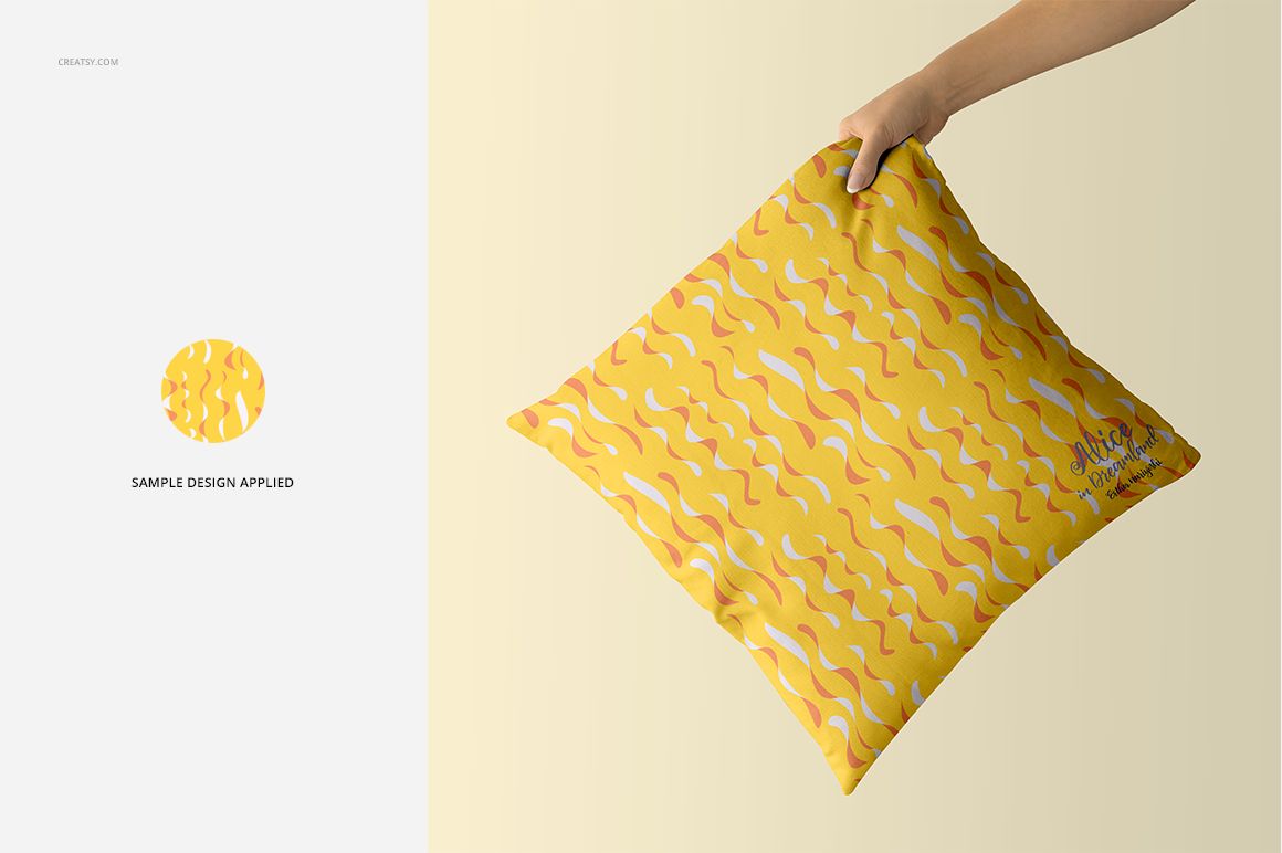 PSD mockup of a square pillow with a yellow surface and abstract orange and white wave pattern, shown in hand.