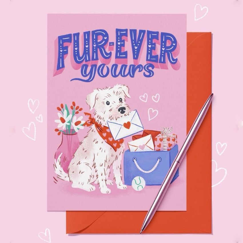 A5 card mockup featuring a pink card with illustrated dog, flowers, envelopes, and gifts, set on a red envelope with a pen.