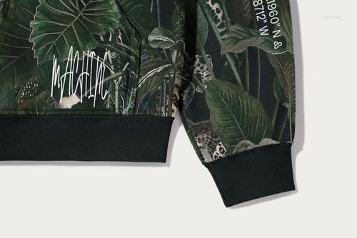 Detailed view of Gildan 18500 hoodie mockup showing leafy green print, white writing, and black sleeve trim.