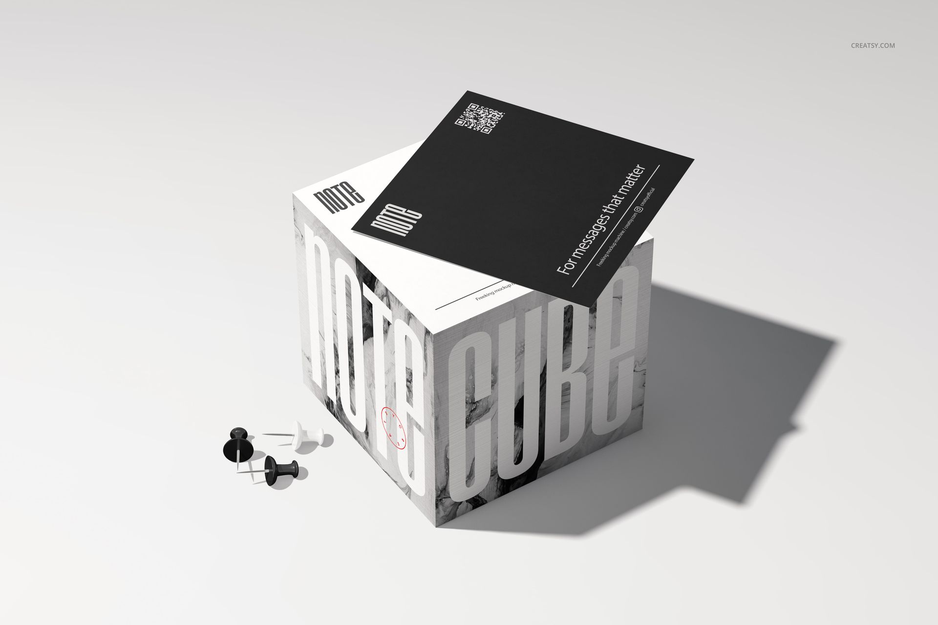 Stationery note cube mockup with bold white text, black and white cards on top, and push pins on a light surface.