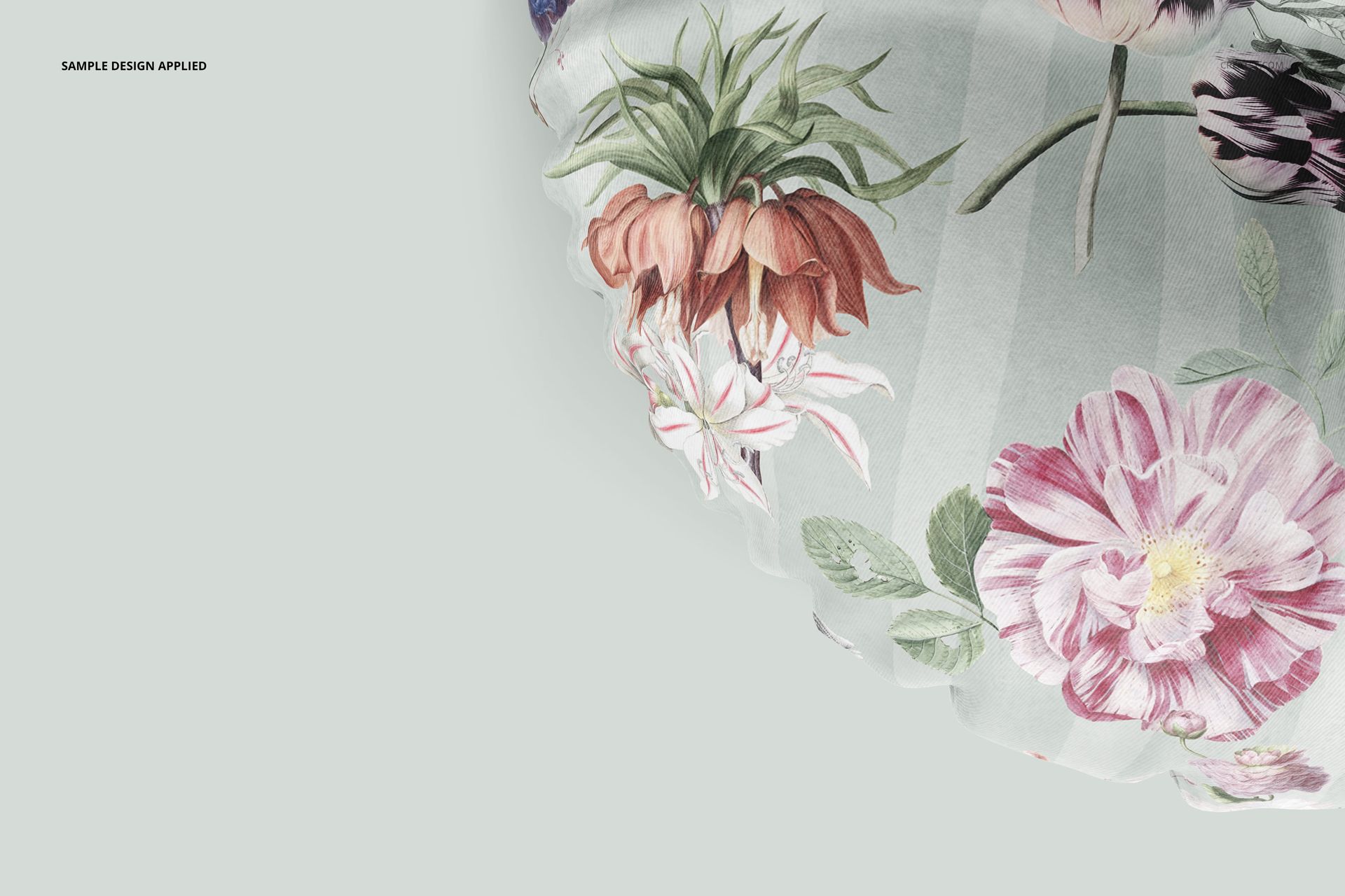 Close-up of a round floor pillow mockup featuring detailed pink and green flowers on a pale striped surface.