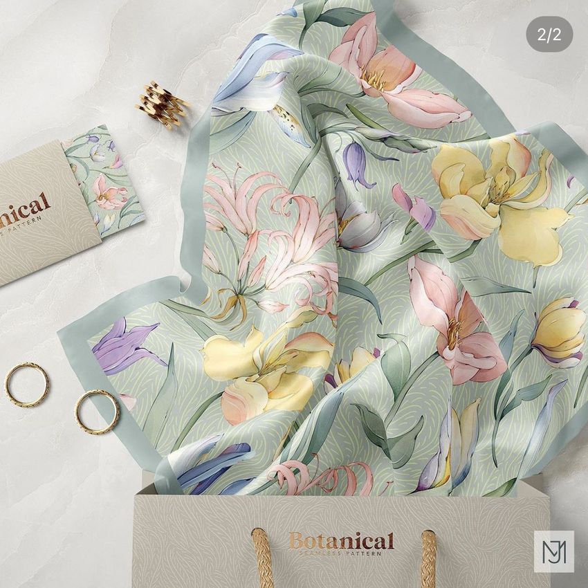 Silk scarf mockup featuring a pastel botanical pattern draped over a shopping bag, with rings and a printed card nearby.