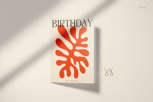 Front view of a 5x7 greeting card mockup with bold red abstract leaf design and large birthday text, on beige background.