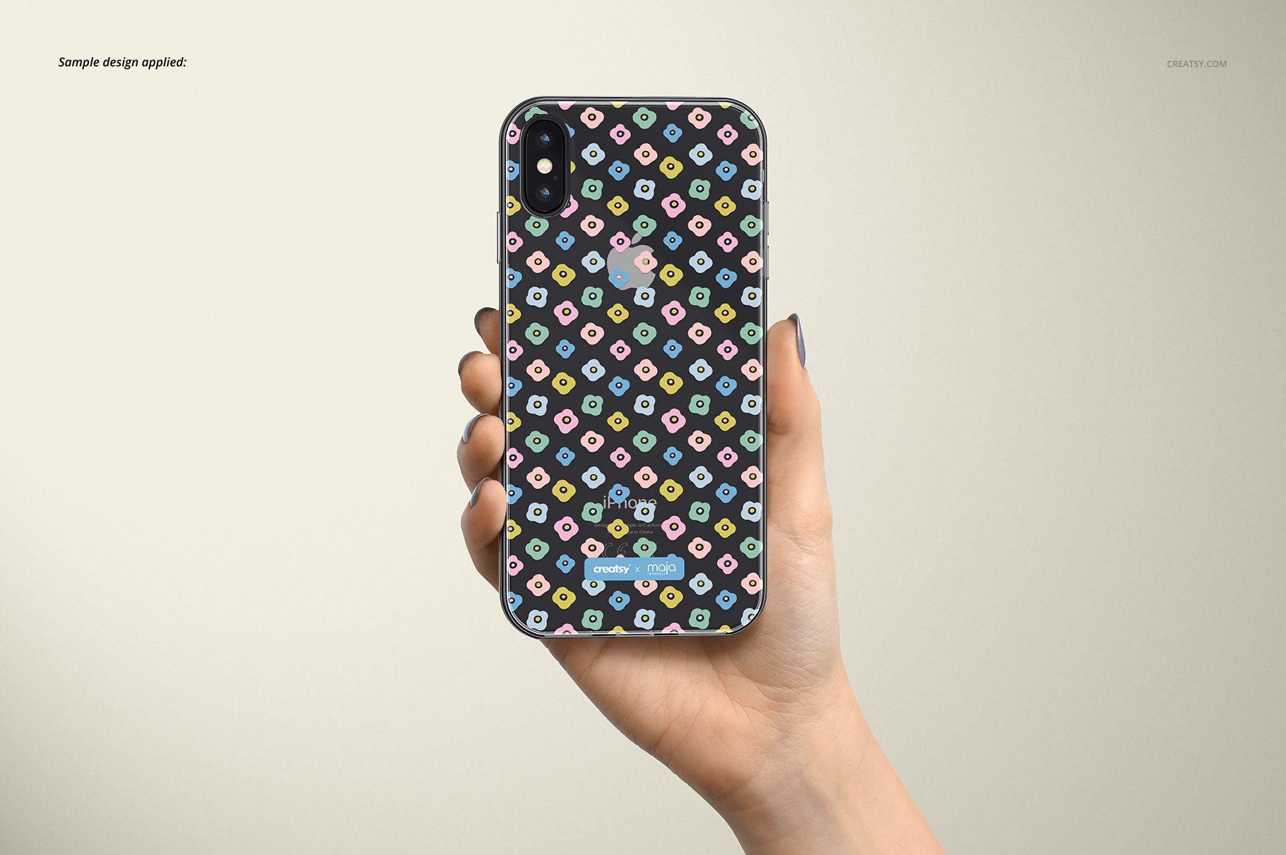 PSD mockup of an iPhone XS clear case with a playful geometric design, displayed in hand with a soft beige background.