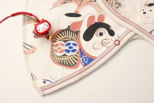 Close-up view of a baby kimono bodysuit mockup with Japanese-inspired animal patterns and red stitching detail.