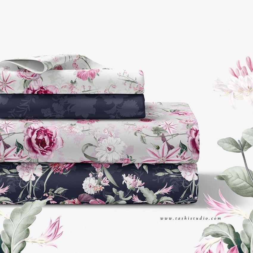Folded bedding set mockup featuring three stacks of floral patterned sheets in pink, white, and navy on a white background.
