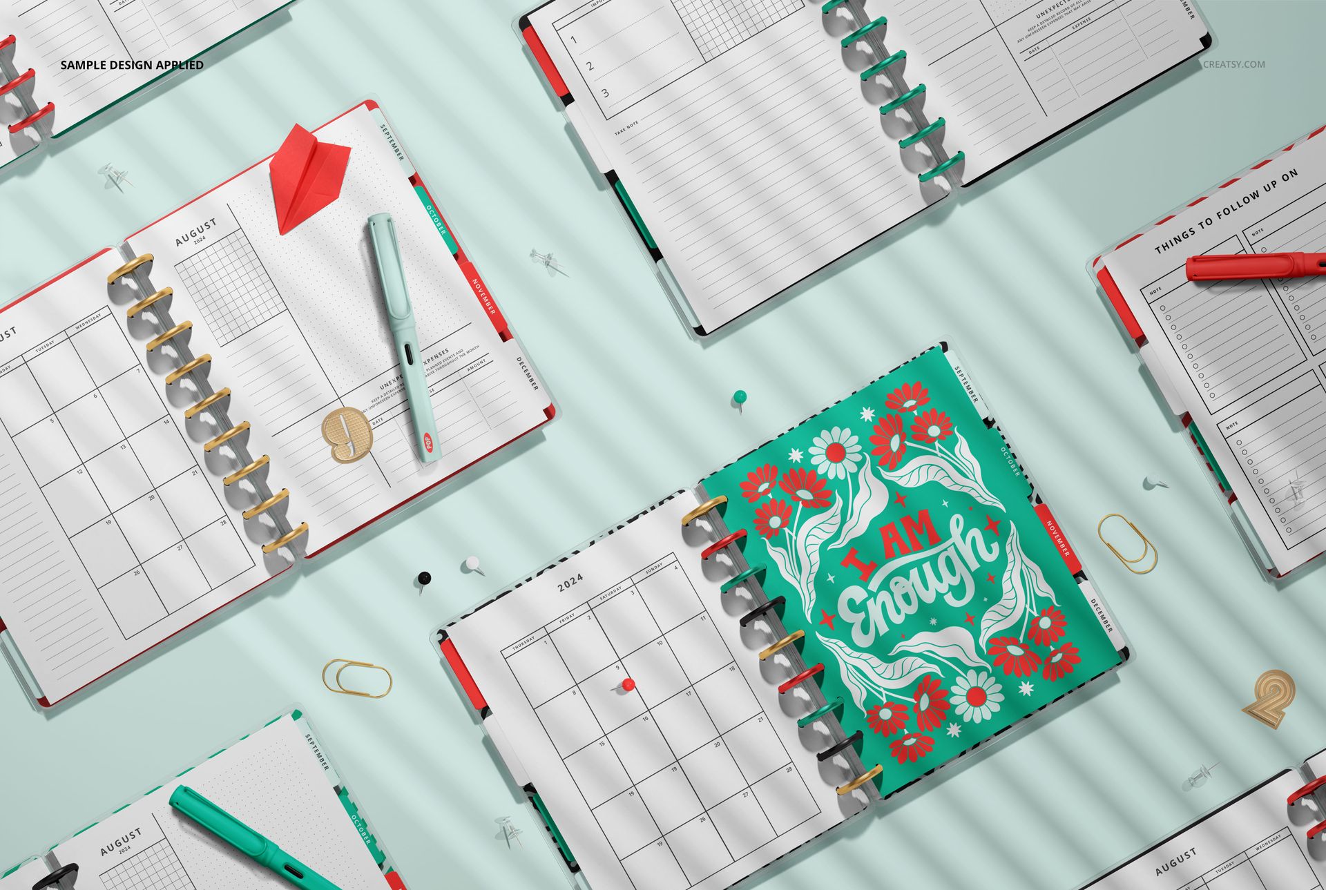 Assorted spiral planners mockup displayed from above, with open pages, pens, and paper clips on a pastel background.