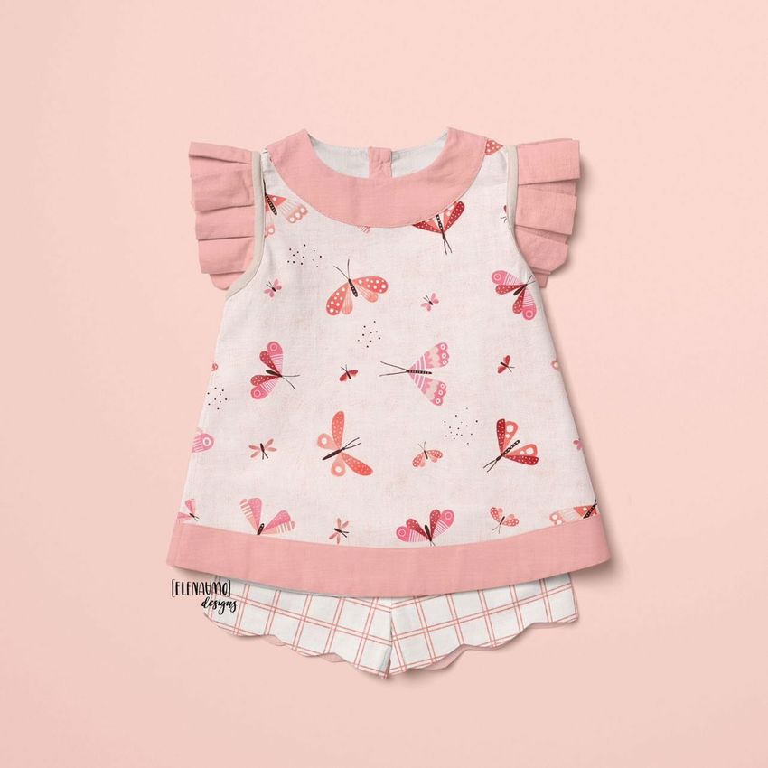 Baby blouse and shorts mockup displayed on a soft pink background, featuring a butterfly pattern and plaid shorts.