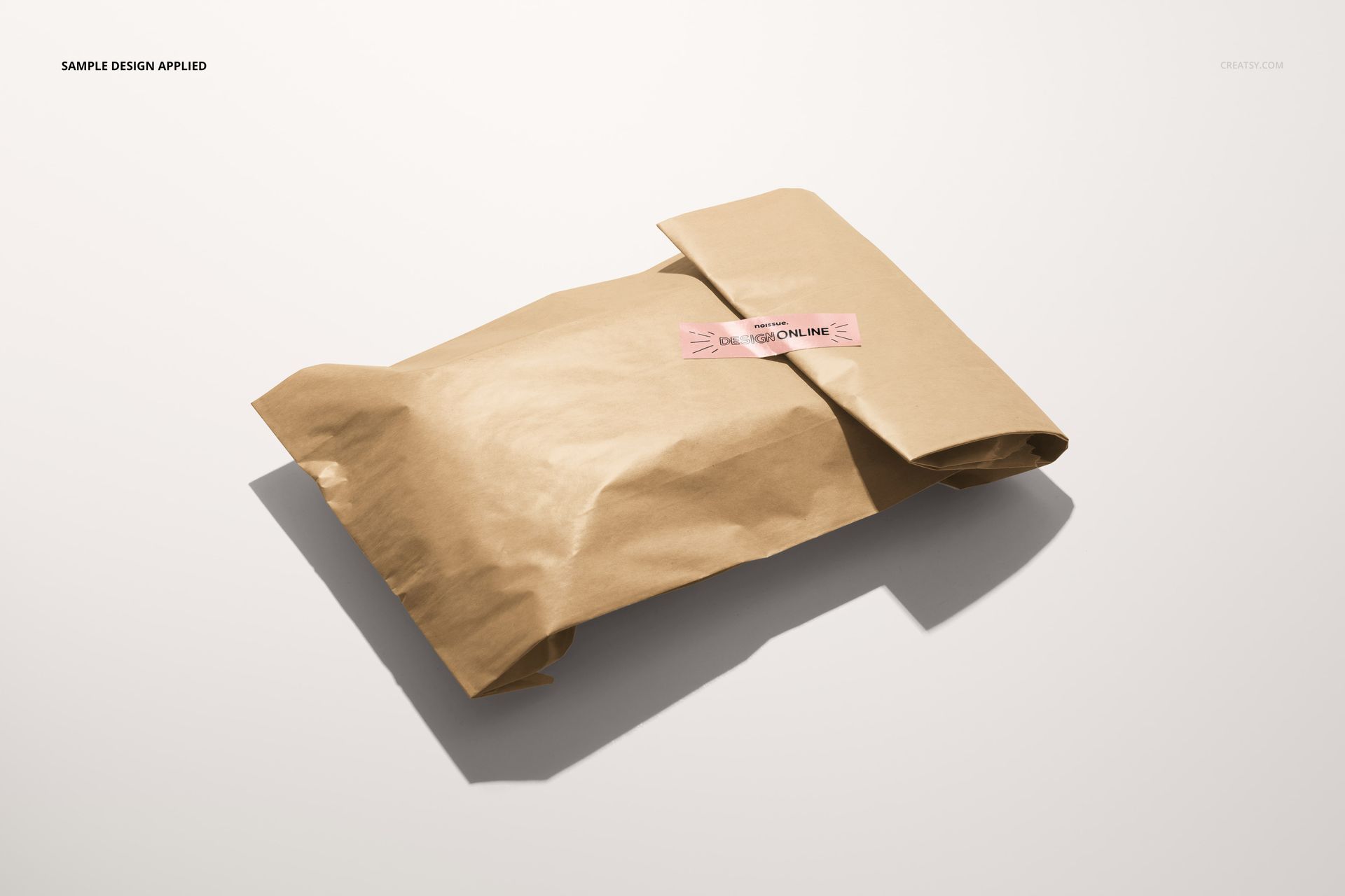Brown paper bag sealed with a rectangular sticker, shown on a light background in a packaging mockup scene.