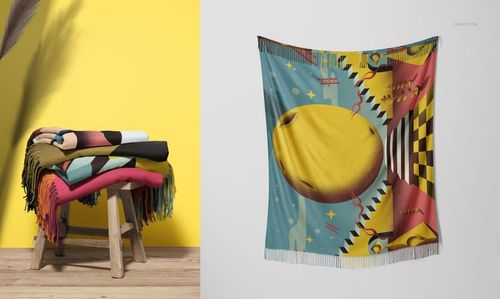 Colorful tassel fringe blankets folded on a wooden stool next to a wall, with a patterned blanket mockup displayed.