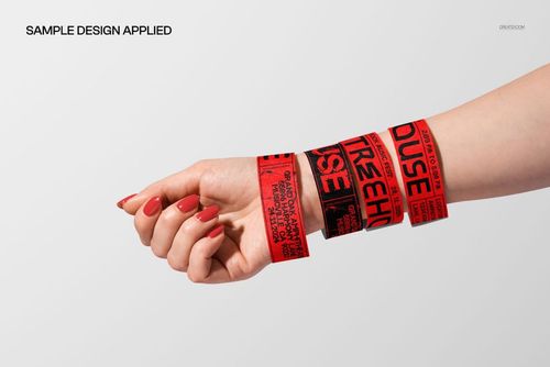 Close-up of a hand wearing multiple red and black event wristbands, displayed for PSD mockup presentation.