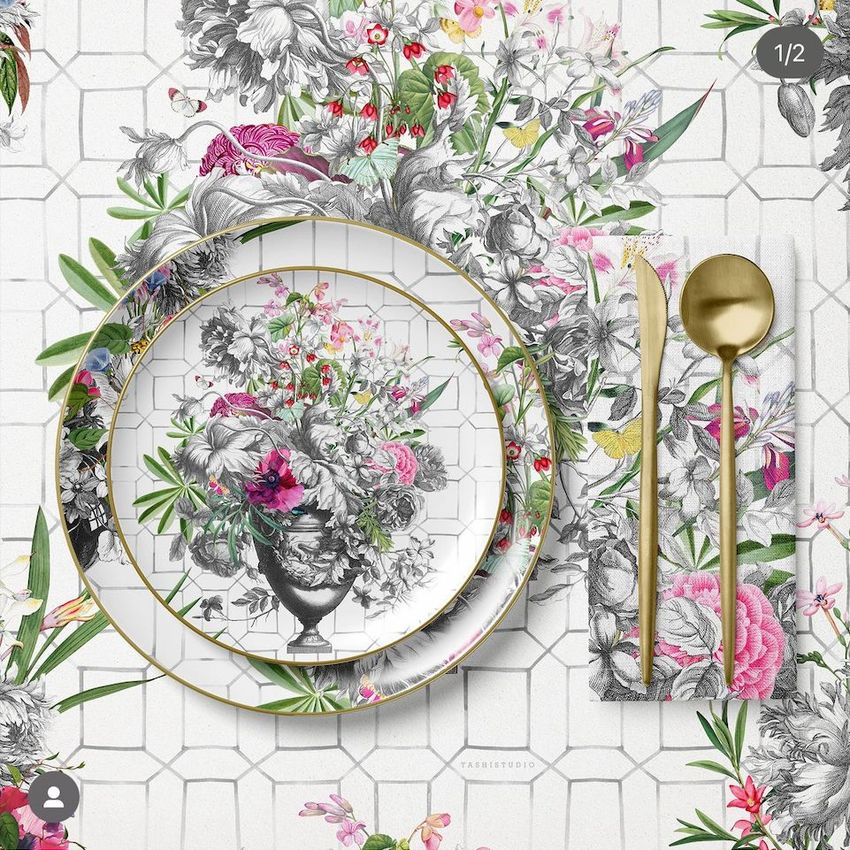Placemat napkin plate mockup featuring a floral arrangement on a white tiled surface with gold cutlery and colorful flowers.