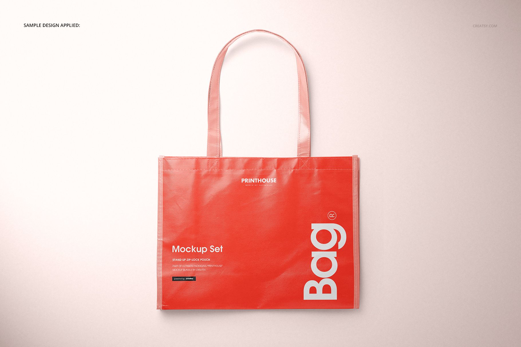 Red laminated tote bag mockup with long handles, white lettering, and a subtle shadow on a pale background.
