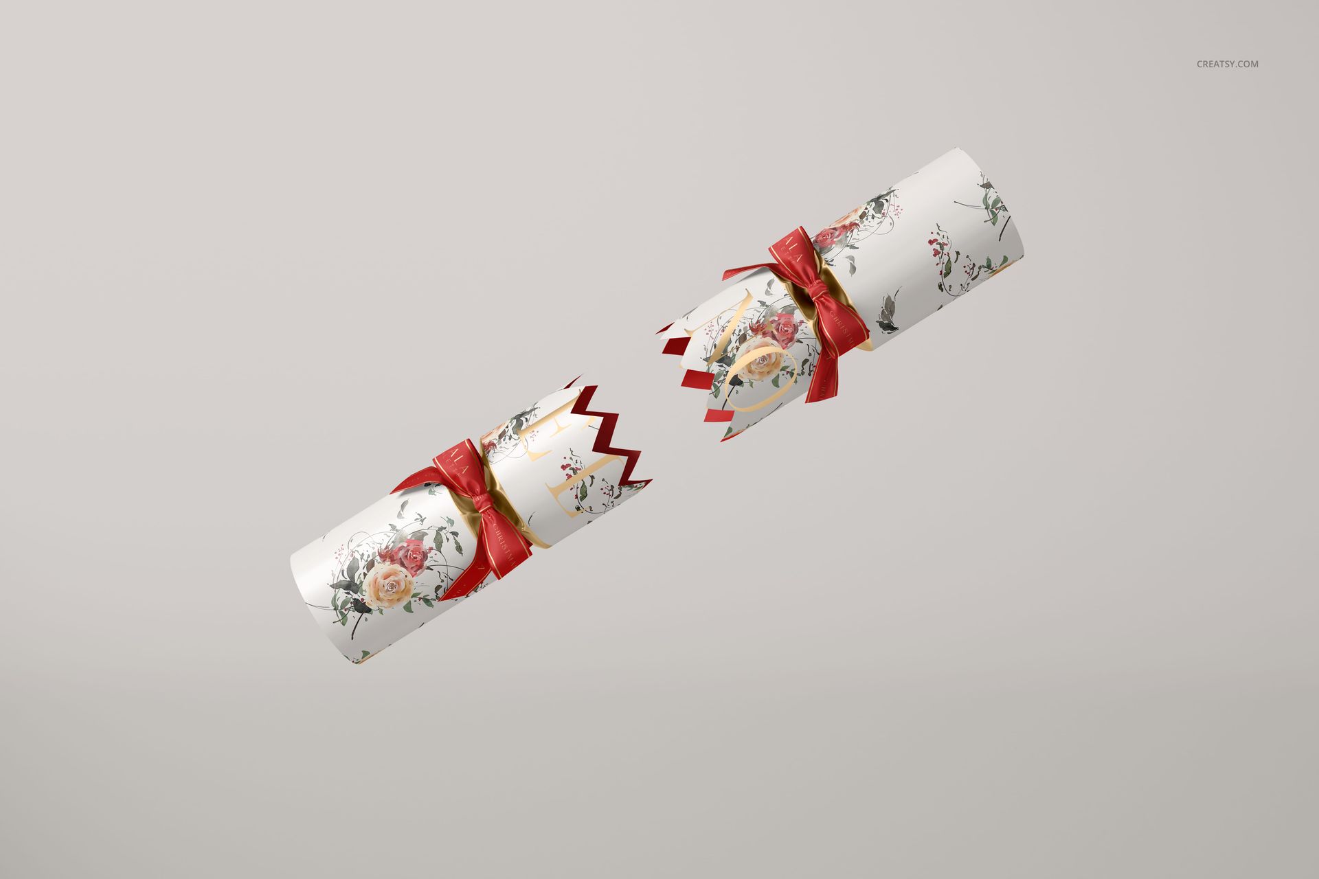 Christmas cracker mockup featuring a floral pattern with red ribbons, displayed on a light neutral background at an angle.