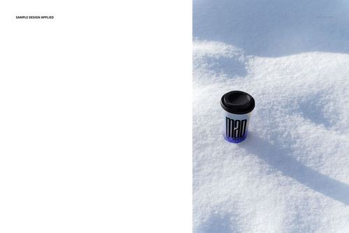 Winter-themed PSD mockup featuring a paper cup with dark lid and blue sleeve placed on a snowy outdoor surface.