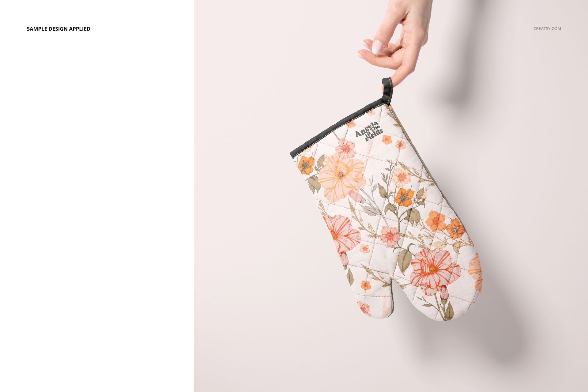 Single oven mitt mockup featuring a quilted surface with a botanical print, displayed by a hand on a pale backdrop.