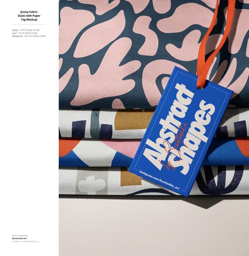Front view of layered jersey fabric mockup featuring colorful abstract designs and a blue paper tag with orange string.