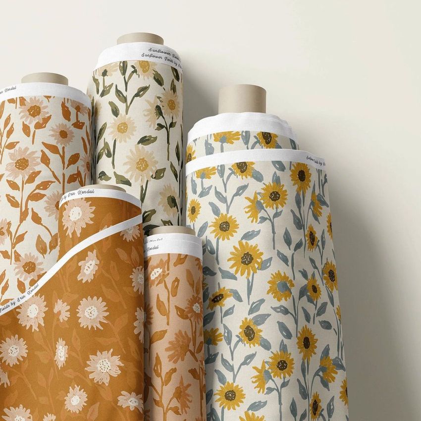 Fabric rolls mockup featuring five upright rolls with floral patterns in yellow, white, and green tones on a neutral background.