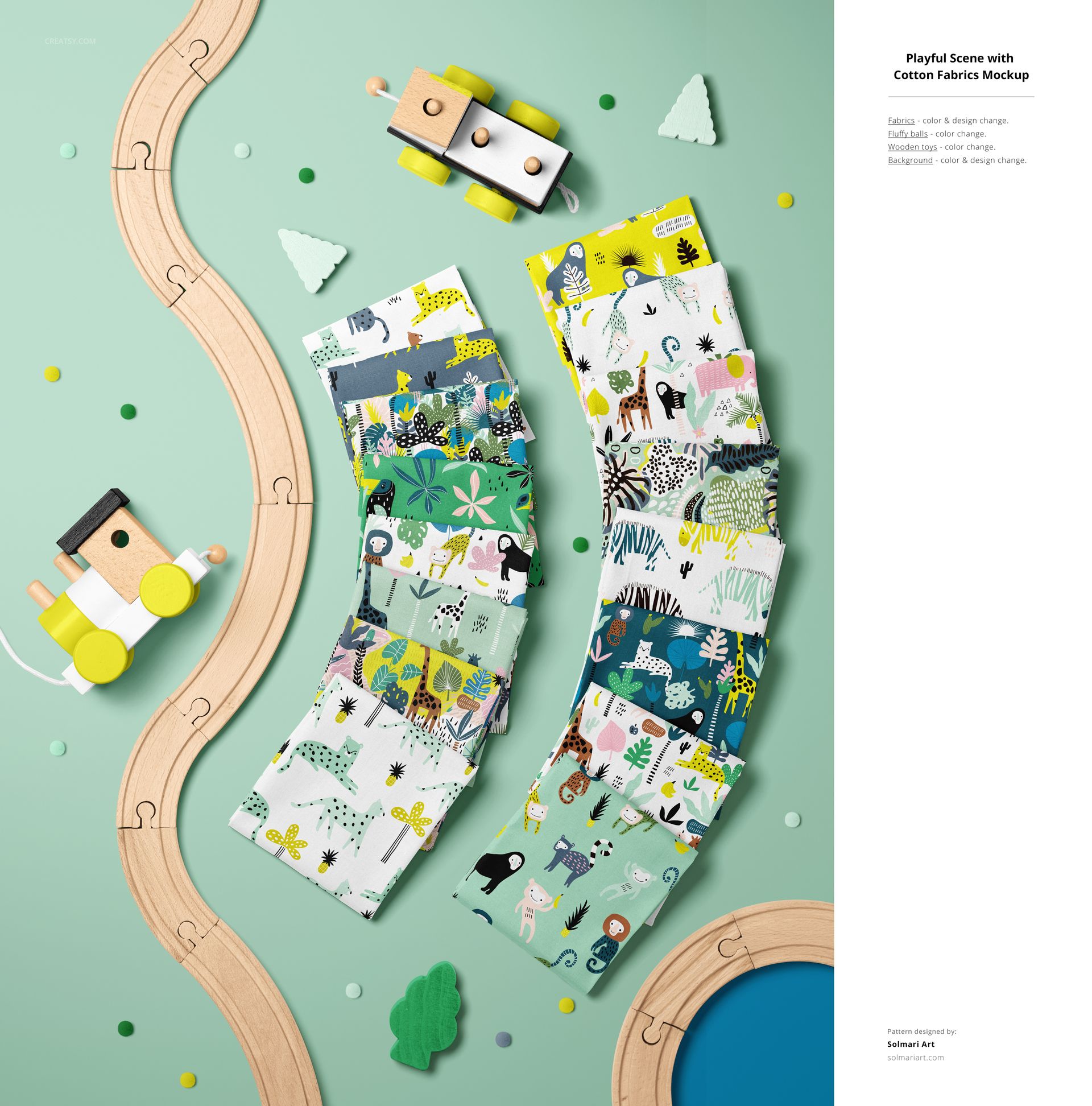 Flat lay of cotton fabric mockup featuring playful prints, wooden train tracks, toy cars, and scattered confetti on a pastel background.