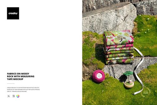 PSD mockup showing folded fabrics with floral patterns on moss, next to a measuring tape and sewing props outdoors.