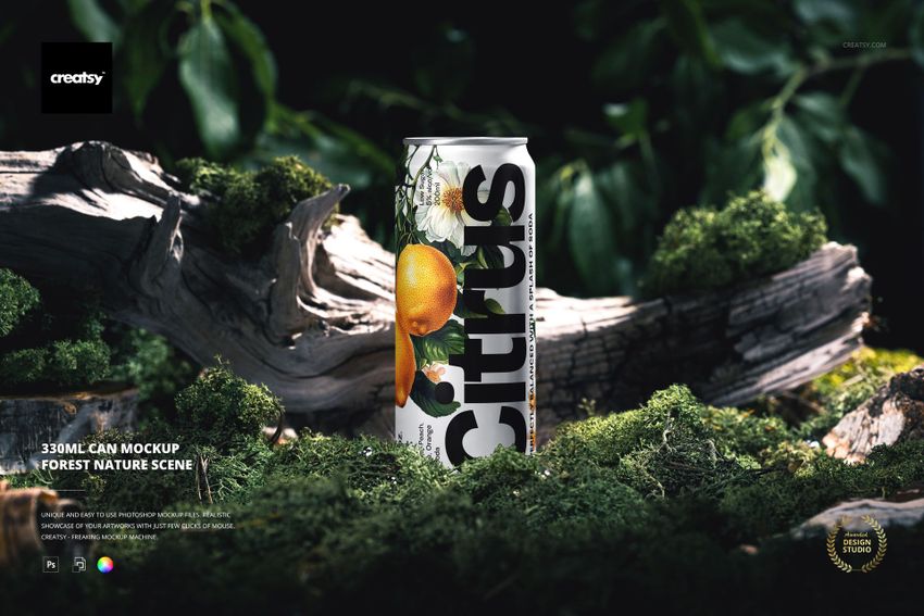 330ml can mockup featuring citrus fruit graphics, standing upright on mossy forest ground with tree bark and greenery.