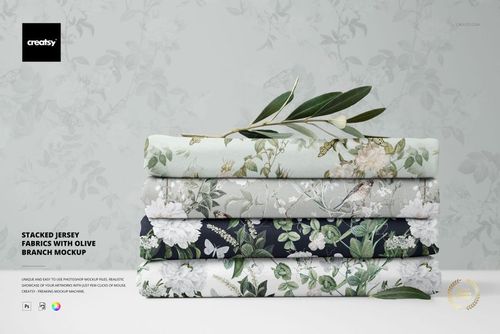 PSD mockup showing stacked floral jersey fabrics in soft green, cream, and dark blue, with an olive branch accent.