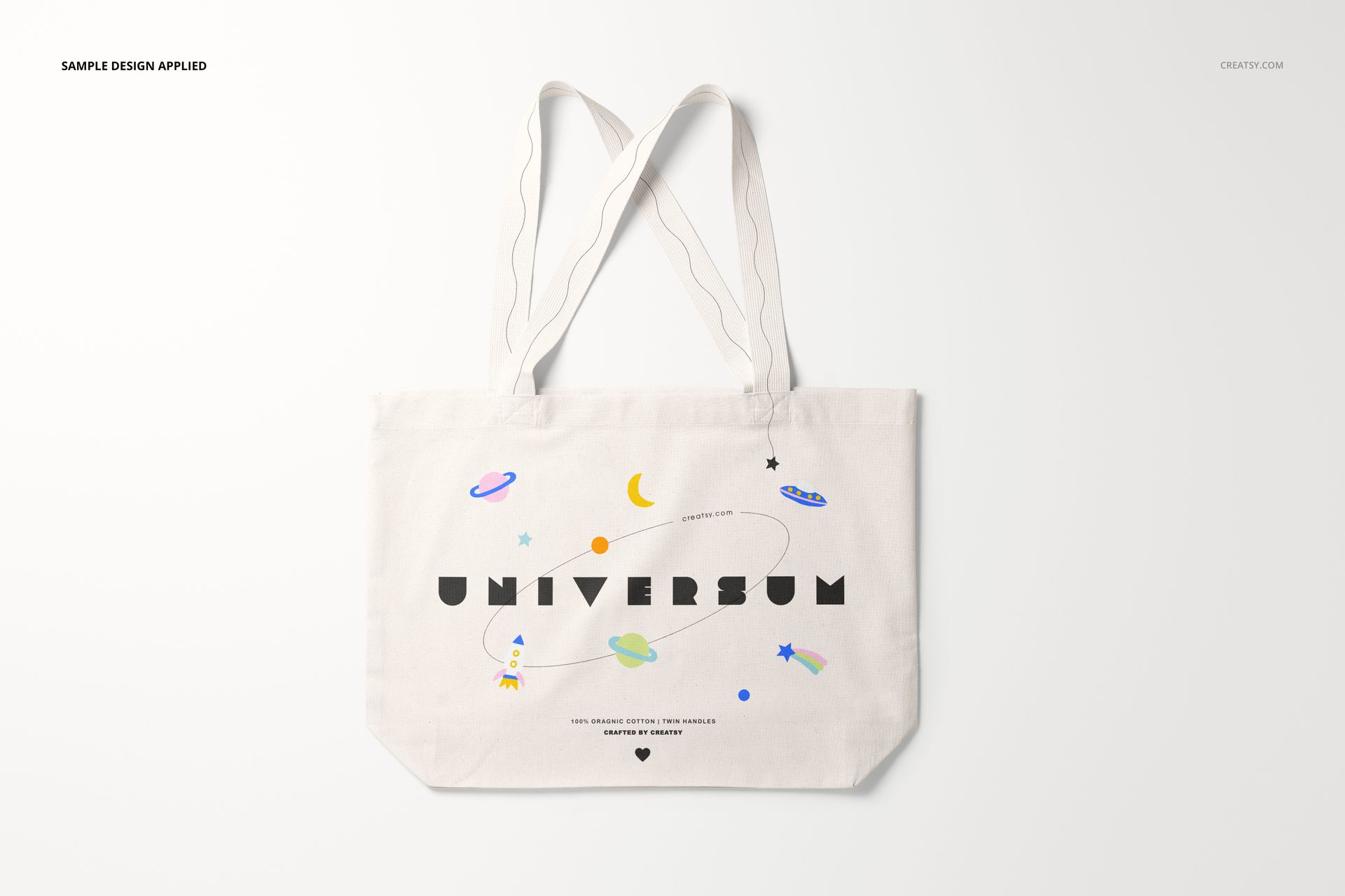 White tote bag mockup displayed on a light background, decorated with planets, stars, and playful typography.