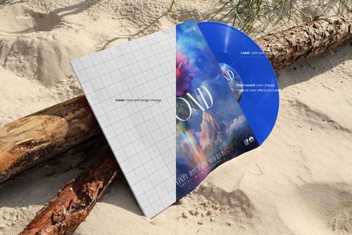 Vinyl record album mockup with a blue disc and partially designed cover lying on sand near driftwood on a wild beach.