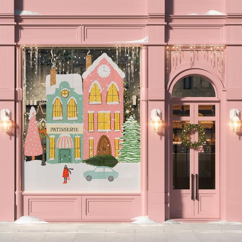 Christmas storefront mockup showing pastel pink and yellow buildings with holiday decorations, snow, and festive lights.