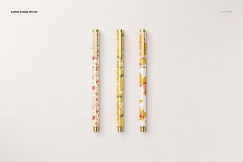 Stationery set mockup featuring three decorative pens with gold accents and colorful designs on a plain surface.