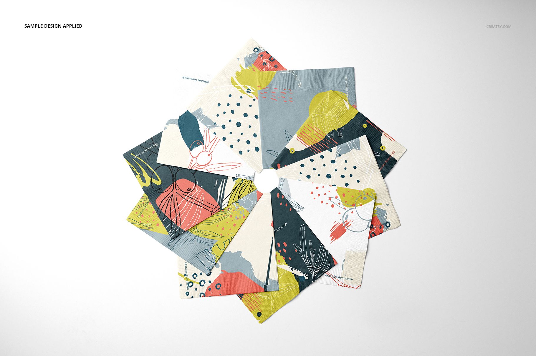 PSD mockup showing a set of paper napkins with multicolored patterns, organized in a fan-like arrangement.