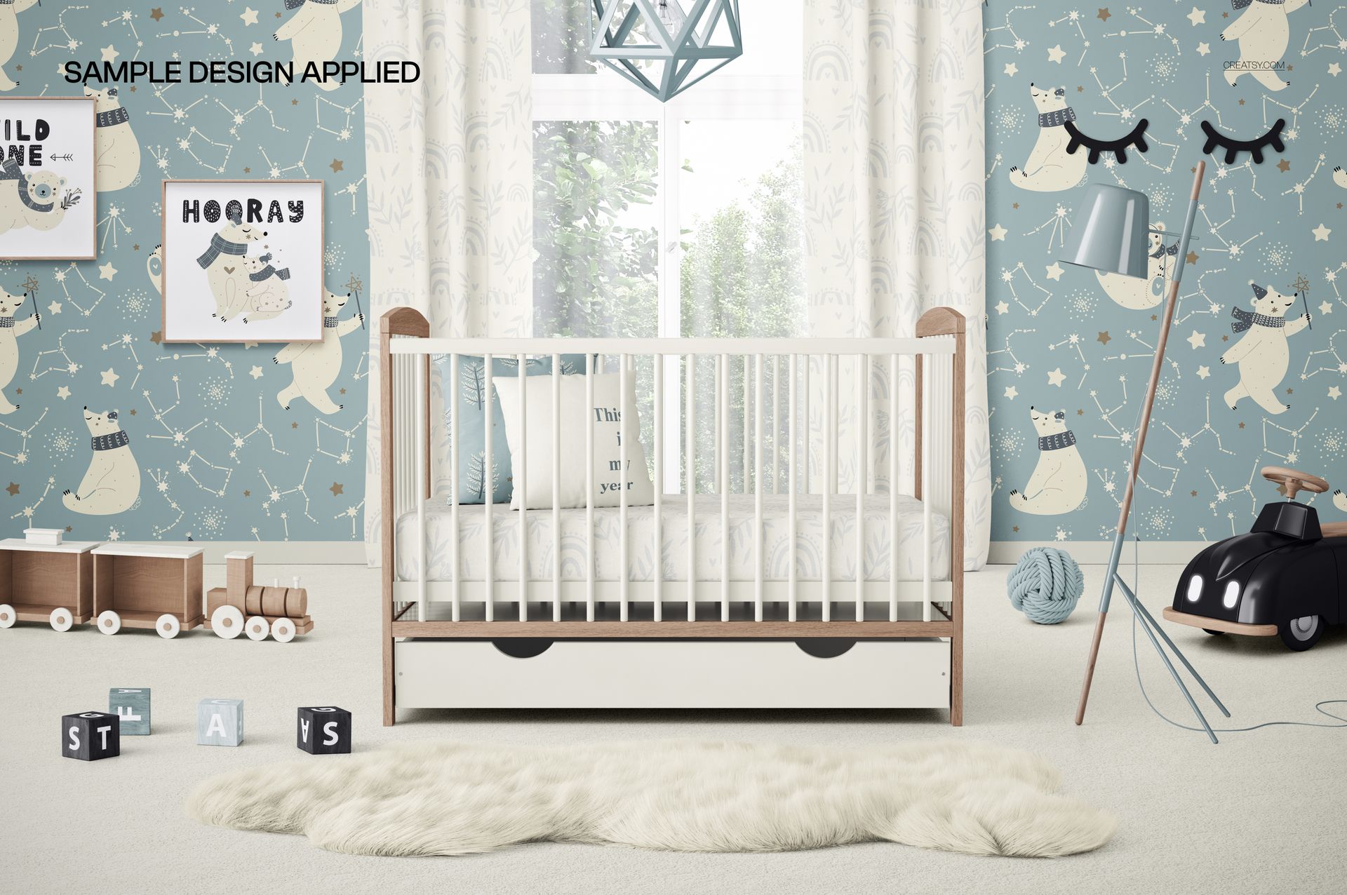 PSD mockup showing a baby crib with bedding and storage drawer, surrounded by whimsical blue nursery decorations.