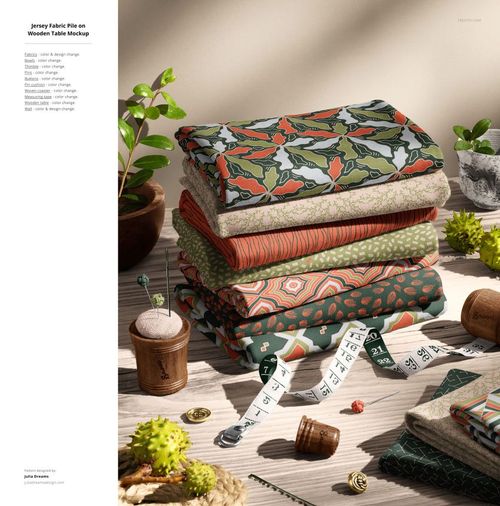 PSD mockup of folded jersey fabrics in various colorful patterns, surrounded by scissors, yarn, and potted plants.