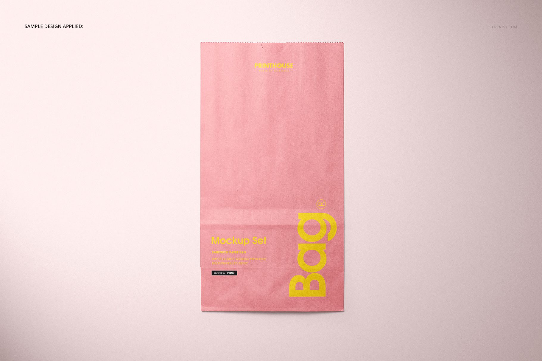 Front view of a pink lunch bag with yellow text, displayed on a light background in a packaging mockup scene.