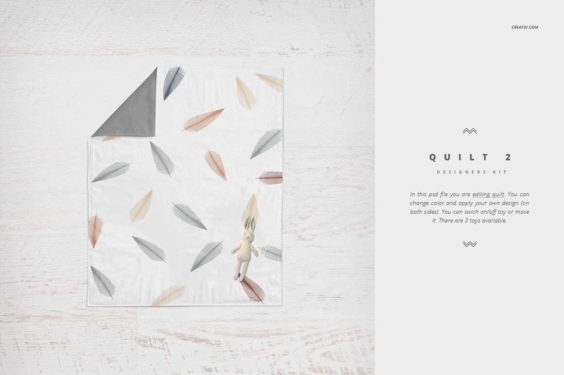 PSD mockup of a crib bedding quilt with gray backing and pastel feather prints, arranged flat with a toy bunny.