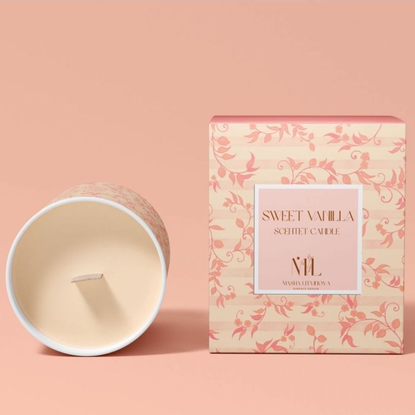 Wooden wick candle mockup featuring a cream-colored candle lying on its side next to a floral patterned box on a peach background.