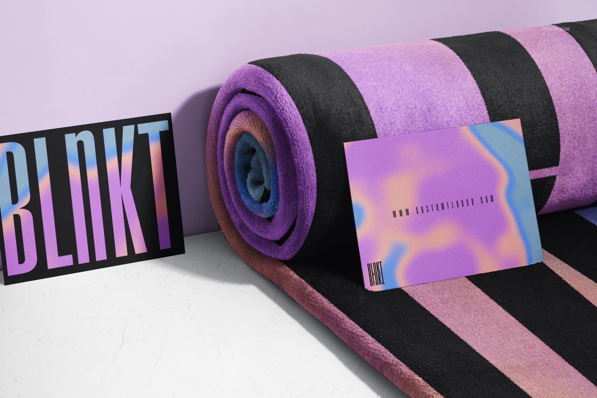 Fleece blanket mockup in a rolled arrangement, displaying vivid stripes and placed next to two abstract design cards.