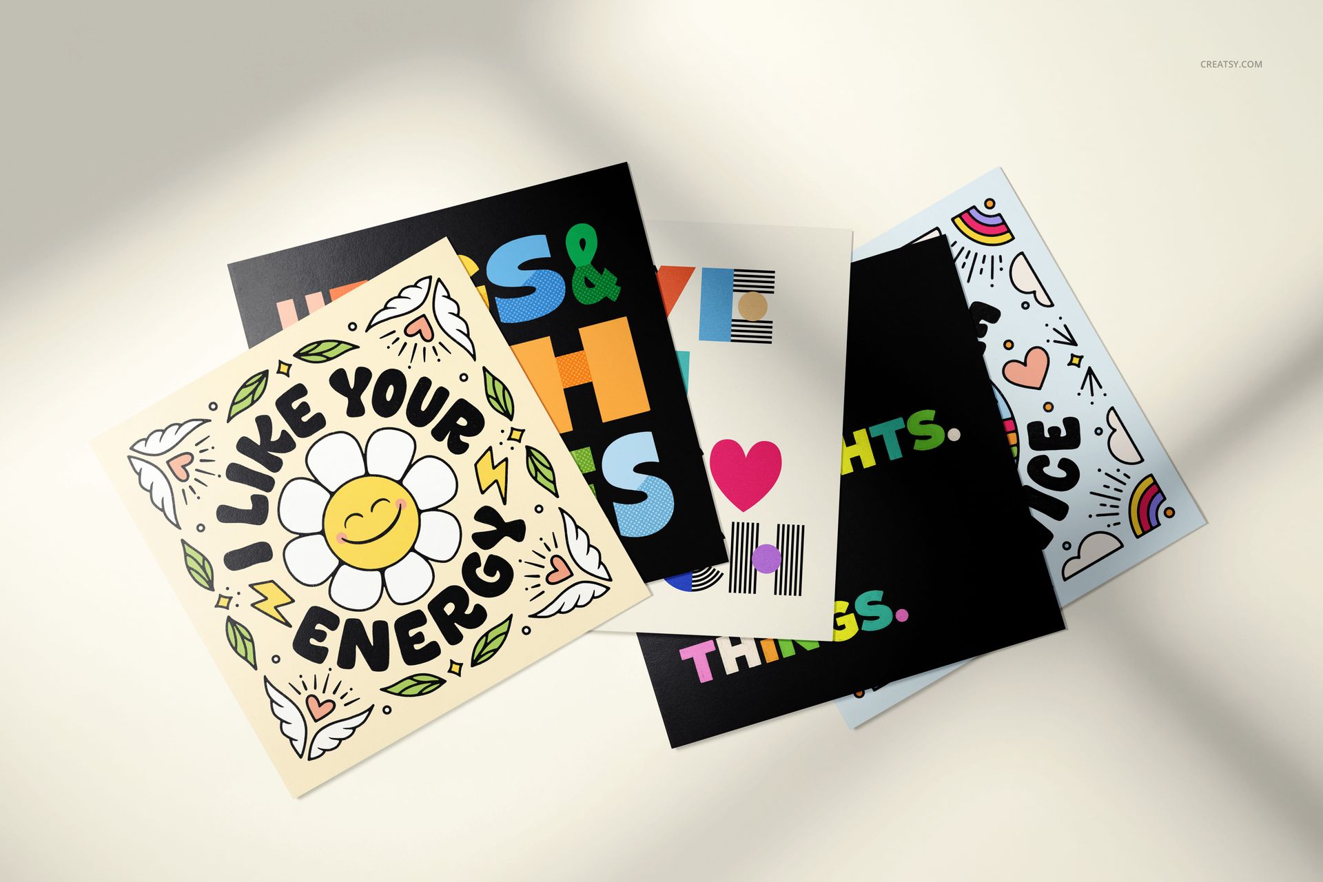 Five square folded greeting cards mockup featuring vibrant graphics, playful patterns, and cheerful typography.
