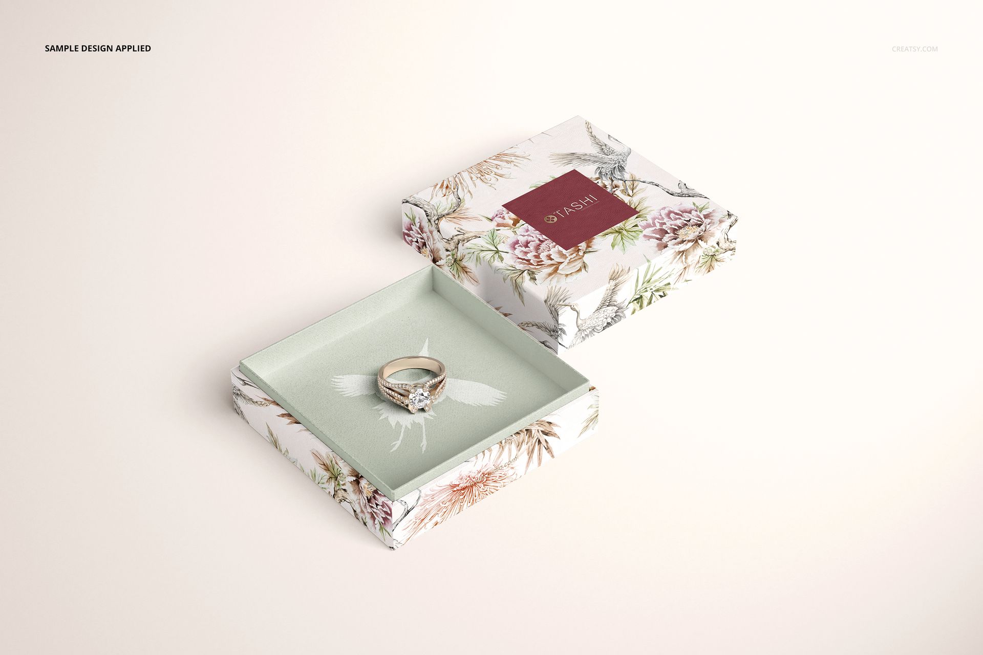Floral jewelry box mockup displayed open, featuring a ring and decorative botanical design, viewed from above.