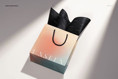 Gift bag mockup featuring a pastel gradient design and black tissue paper, displayed on a light surface with shadows.
